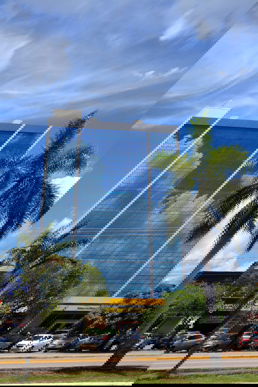 a tall building with a sky reflection on the side of it